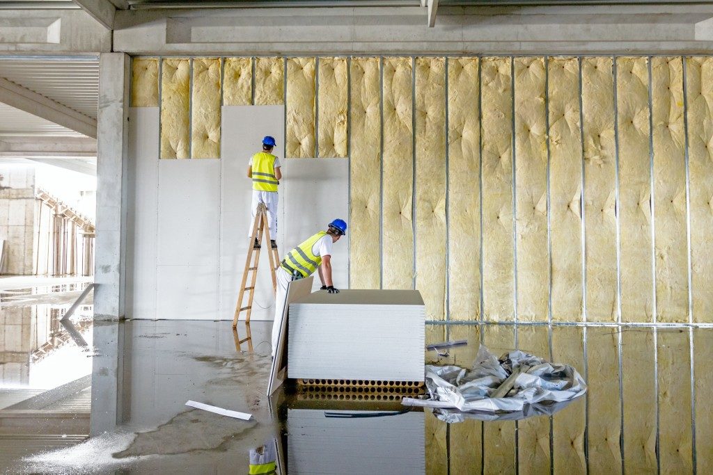 two men installing plasterboards