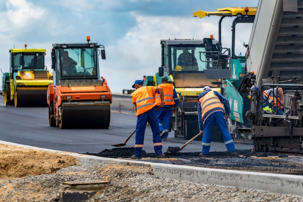 Workers applying asphalt road construction