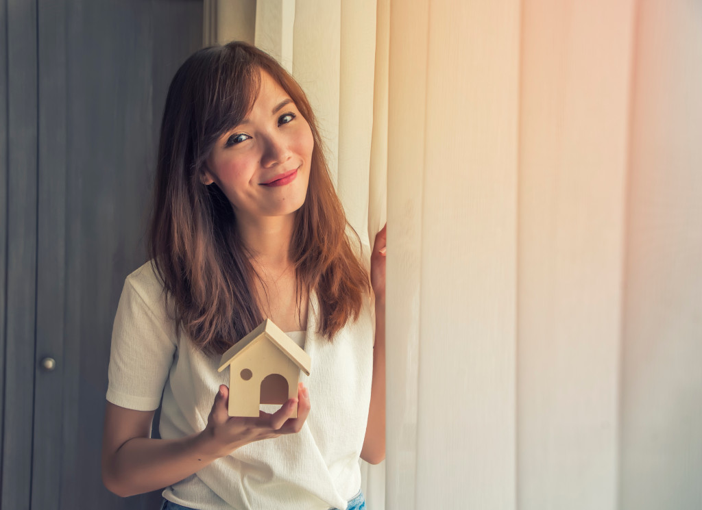 woman holding house miniature