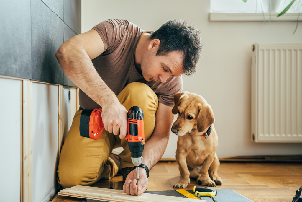 Man with dog doing man cave project