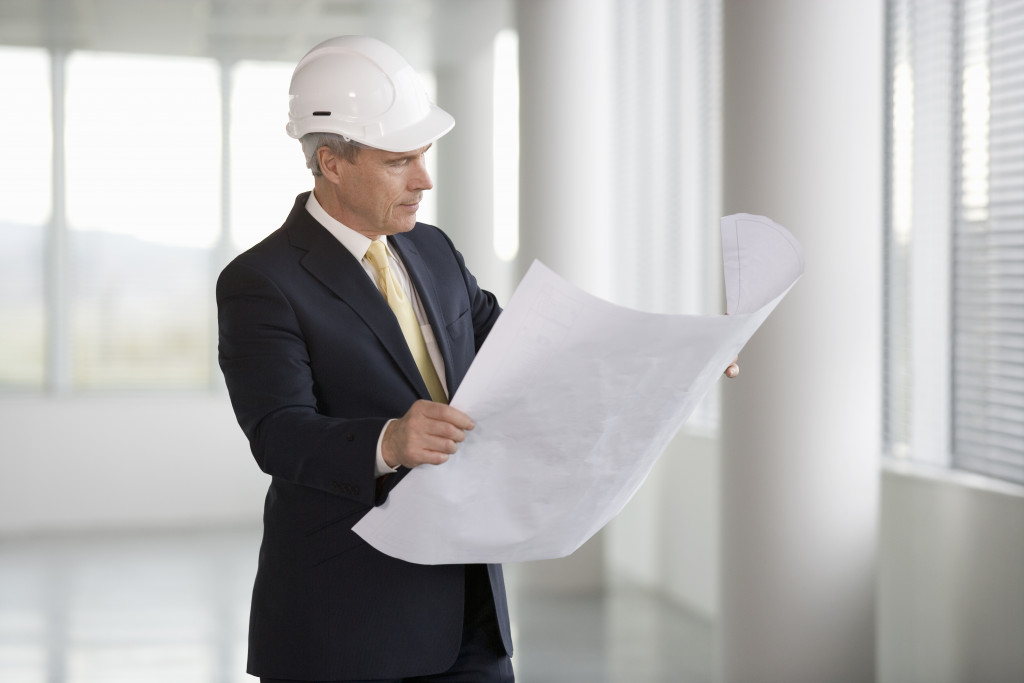 man in hard hat checking construction plans