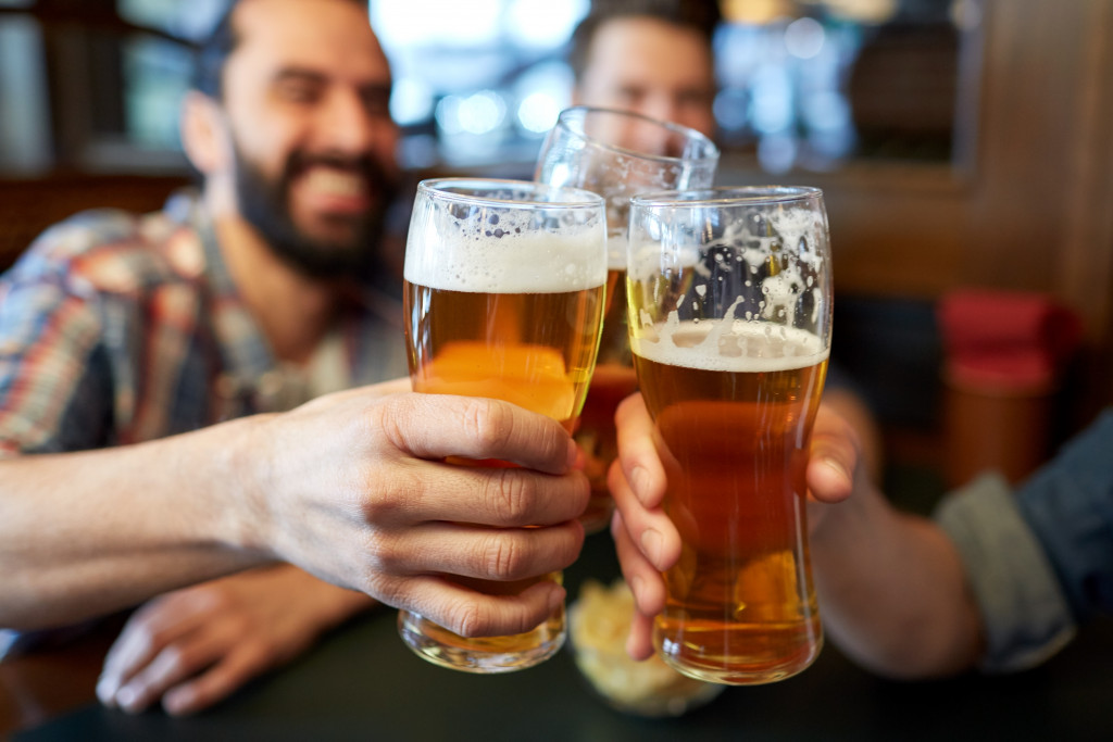 Men clinking glasses and drinking beer in a pub