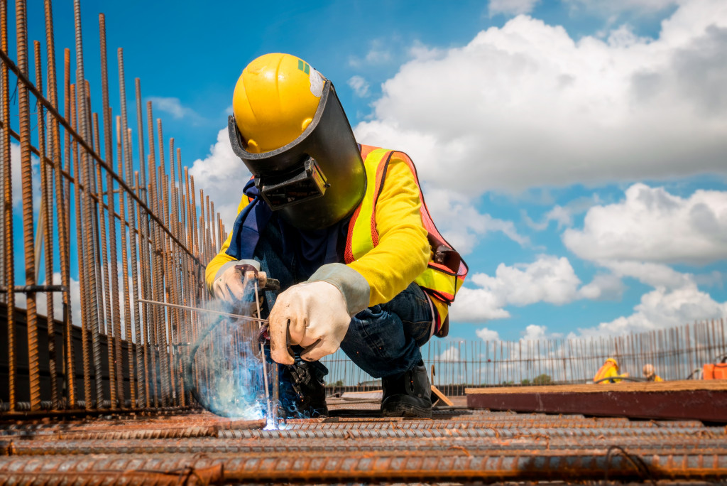 a construction worker welding a steel rod