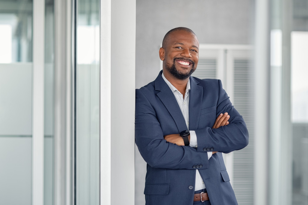 african american executive in workplace wearing a suit smiling