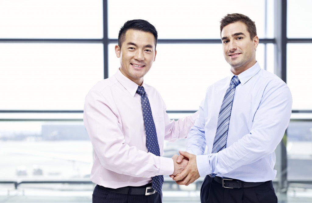 2 businessmen shaking hands smiling