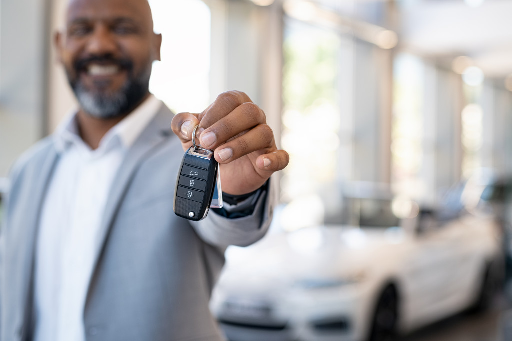 A car dealer handing car keys