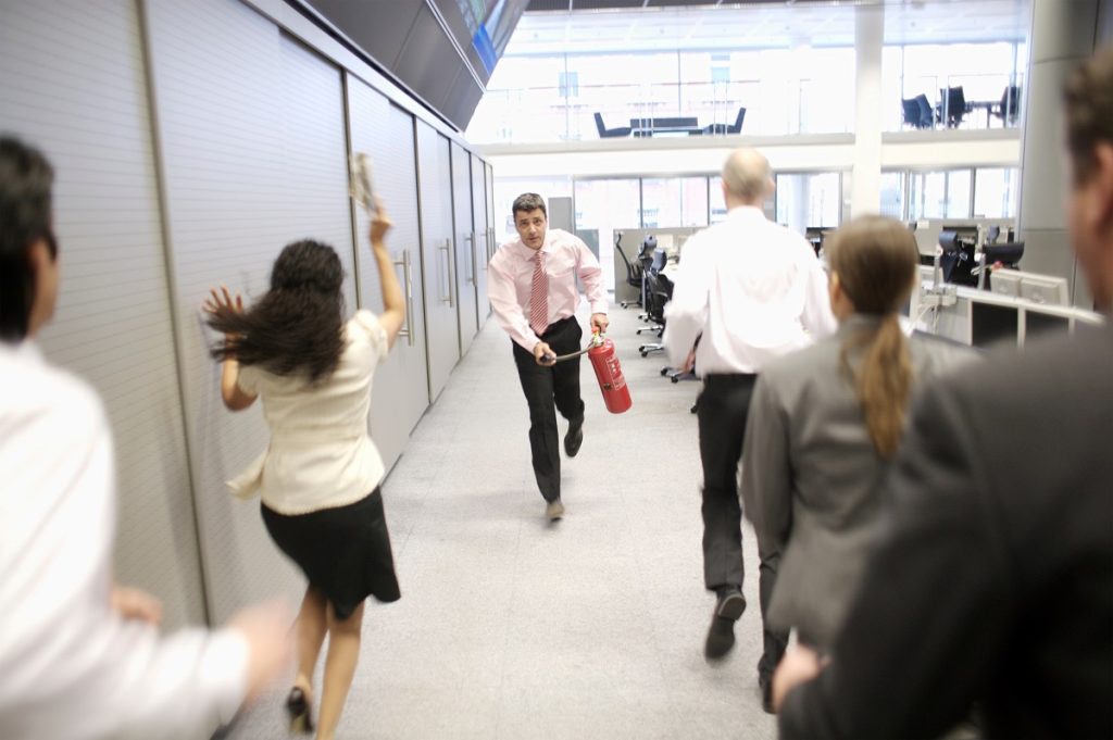 businessman running with fire extinguisher